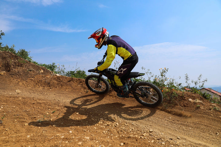 Surron Light Bee X in action on a dirt trail, kicking up dust with powerful acceleration